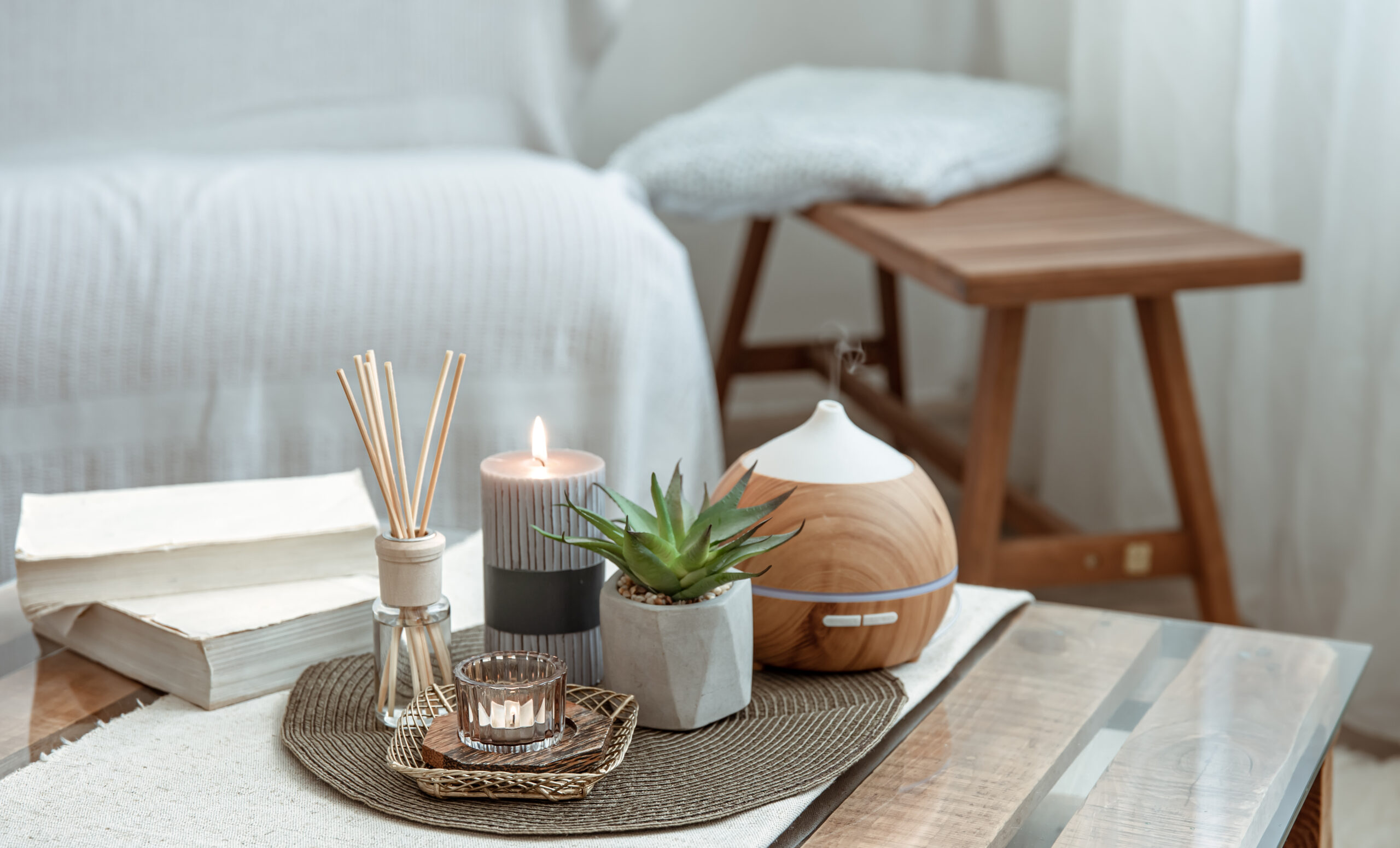 composition with incense sticks diffuser candles and books on the table in the interior of the room scaled - Reconectar através do lar